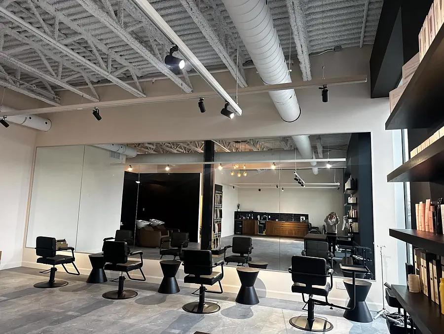 Salon de coiffure : grande cloison vitrée et miroirs muraux posés sur mesure.